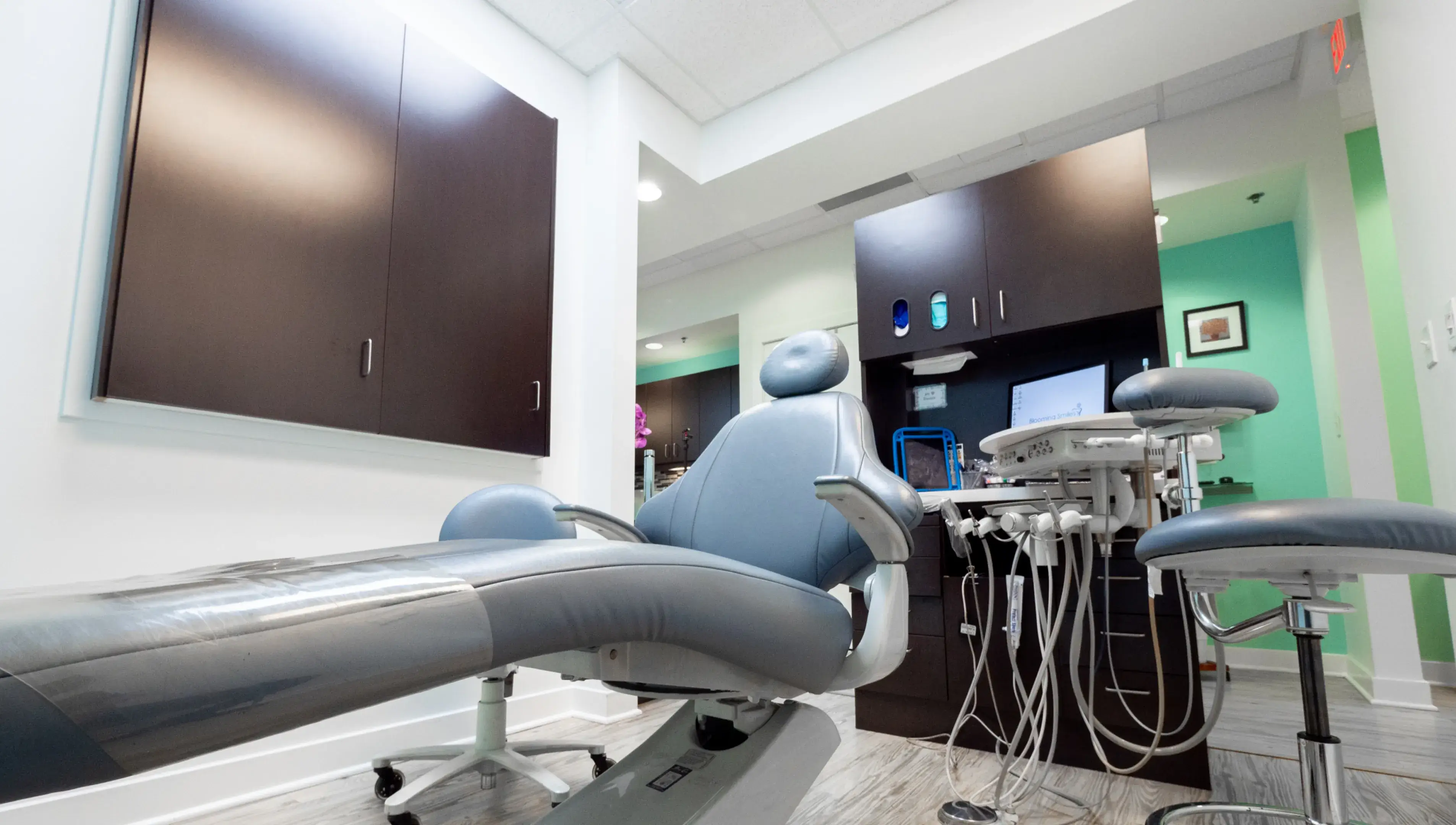 a dental room with a chair and a monitor