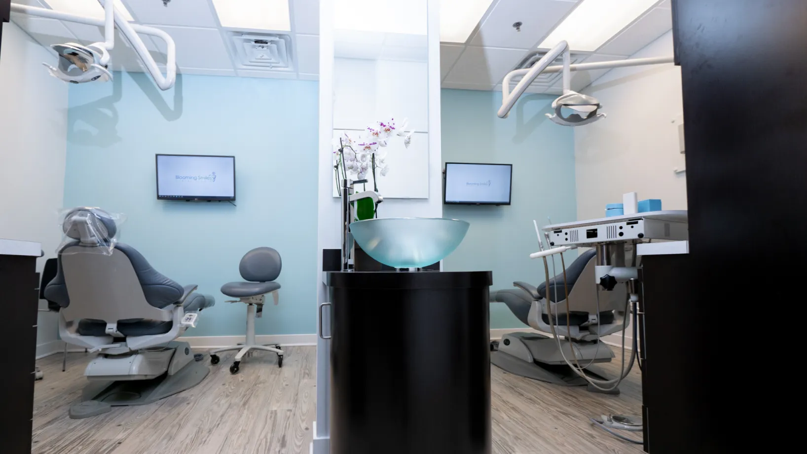a dentist's office with chairs and monitors